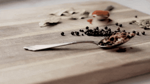 Cuchara con especias sobre una tabla de madera